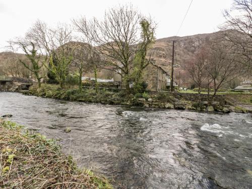 a river with rocks in the middle of it at Encil in Caernarfon