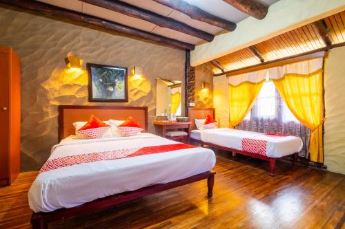 En eller flere senge i et værelse på Capital O 2640 Rumah Kayu Cottage Syariah