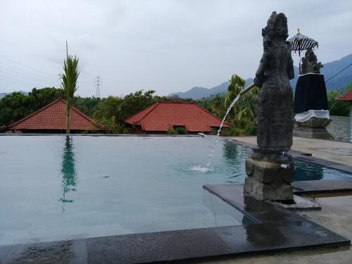 a fountain in the middle of a swimming pool at Eliska Sari Bungalows Sumberkima in Pemuteran