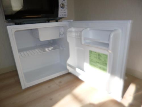 an empty refrigerator with its door open in a room at THE MICKEY CARLTON Ohashi 206 in Shiobaru