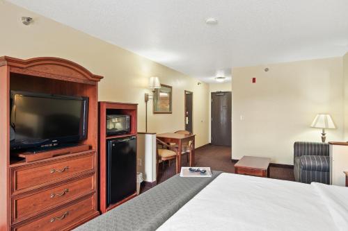 a hotel room with a bed and a television at Stay USA Hotel and Suites in Hot Springs