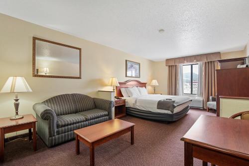 Stay USA Hotel and Suites في هوت سبرنغز: غرفه فندقيه بسرير وكرسي