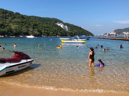 a group of people in the water at a beach at Paraiso Azul in Acapulco