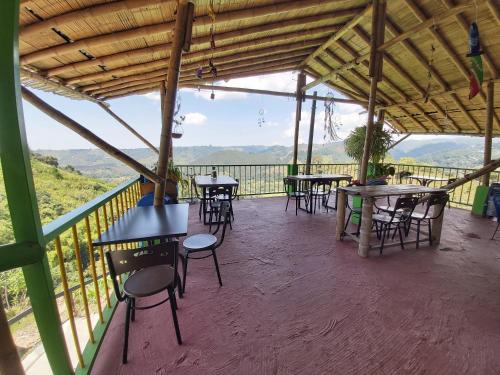 a group of tables and chairs on a balcony at Hostal y Camping Los Girasoles in Salento
