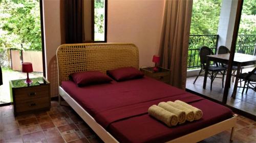 a bedroom with a bed with two towels on it at Casa La Guaria in Sámara