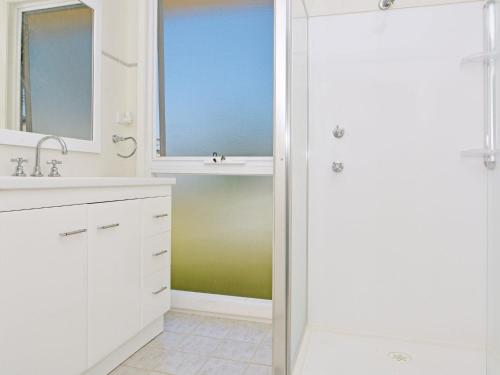a white bathroom with a sink and a mirror at Morisset Waterview 1bdr Studio in Morisset East