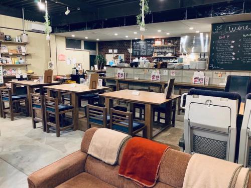 a restaurant with tables and chairs and a couch at 4S STAY Awaikeda Ekimae in Miyoshi