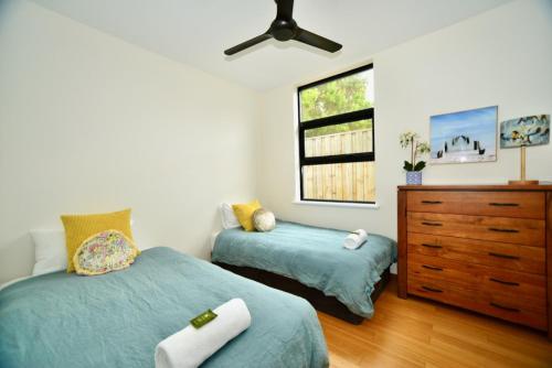 a bedroom with two beds and a dresser and a window at Bonnie View - a wonderful view up the river Experience Augusta in Augusta