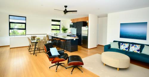 a living room with a blue couch and a kitchen at Bonnie View - a wonderful view up the river Experience Augusta in Augusta