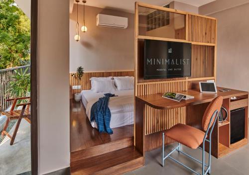 Una habitación de hotel con una cama, un escritorio y un televisor. en Minimalist Poshtel & Suites, en Nueva Delhi