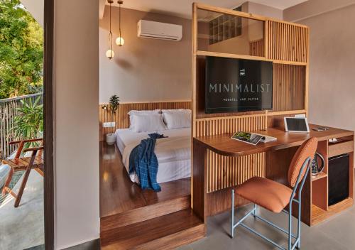 a hotel room with a bed and a desk and a television at Minimalist Poshtel & Suites in New Delhi