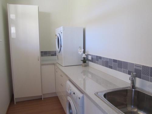 a kitchen with a sink and a white refrigerator at Bonnie View - a wonderful view up the river Experience Augusta in Augusta