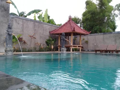 a swimming pool with a gazebo in a backyard at Villa Eliska Sari Sumberkima in Pemuteran