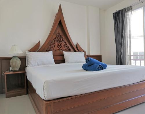 a bedroom with a large bed with a blue towel on it at Sure Guesthouse in Kamala Beach