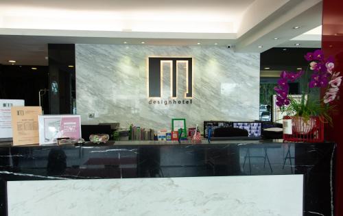 a counter in a hotel with a sign on the wall at M Design Hotel @ Pandan Indah in Kuala Lumpur