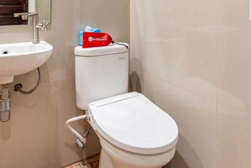 a bathroom with a white toilet and a sink at RedDoorz Syariah @ Soekarno Hatta Indah 2 in Blimbing