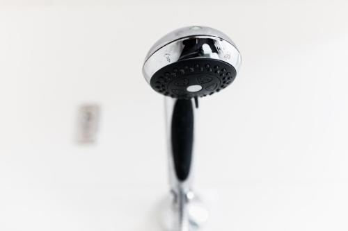 a close up of a shower head with a black tie at St Ives Apartments in Hobart