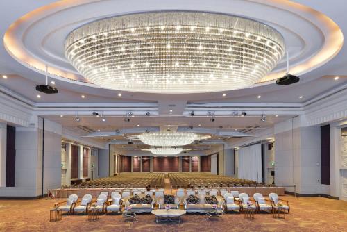 une grande salle de banquet avec des chaises et un grand lustre dans l'établissement Miracle Grand Convention Hotel, à Bangkok