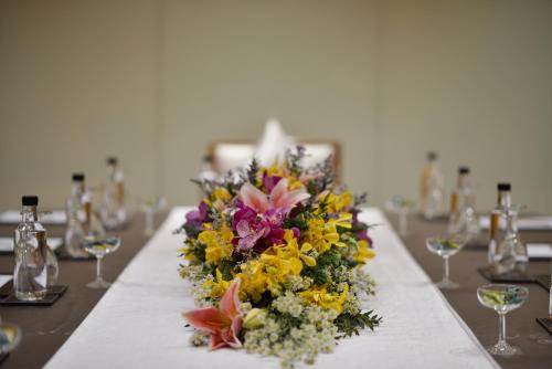 a table with a bouquet of flowers and wine glasses at Miracle Grand Convention Hotel in Bangkok