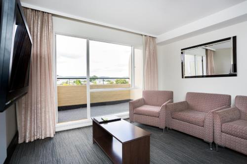 a living room with two chairs and a large window at St Ives Apartments in Hobart