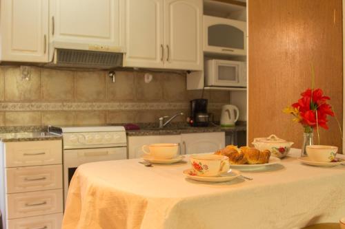 - une cuisine avec une table avec des tasses et des croissants dans l'établissement Departamento céntrico en el corazón de la ciudad de Mendoza, à Mendoza