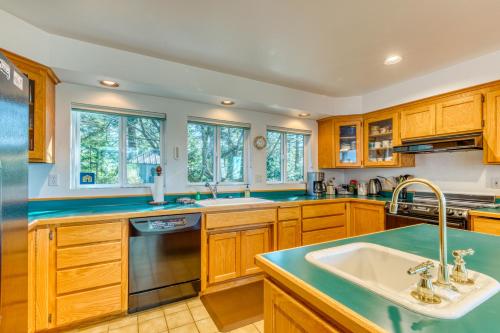 a kitchen with wooden cabinets and a sink at Forest Ridge Retreat in Coos Bay