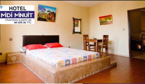 a bedroom with a large bed with red pillows at Midi Minuit in Antananarivo