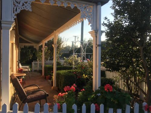 a gazebo with a chair and flowers at Bellamona Cottage Longford in Longford
