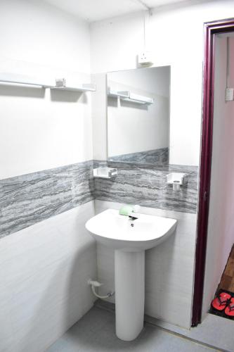 y baño con lavabo blanco y espejo. en Arachiwil Green Nature Resort en Puttalam