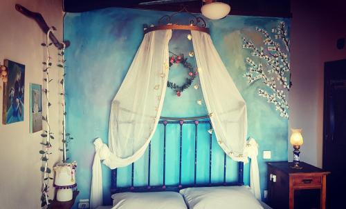 a bedroom with a canopy bed with a curtain at Feggaropetra Inn Magic Mountain House in Palaios Panteleimon