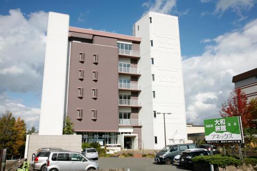 a building with cars parked in a parking lot at Granvillage Toya Daiwa Ryokan Annex in Lake Toya