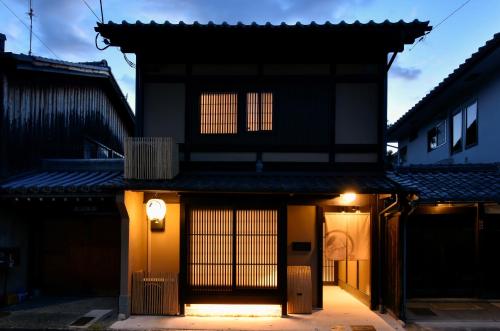 a black building with a light on the side of it at Rinn Premium Machiya Yae in Kyoto
