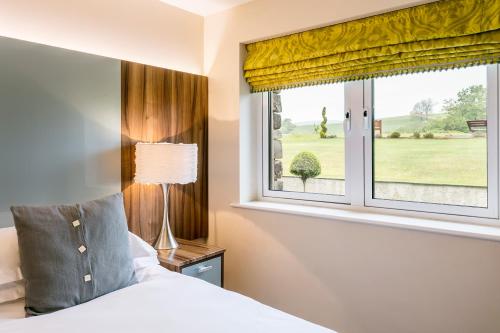 a bedroom with a bed and a window at Golf Apartment @ Carus Green in Kendal