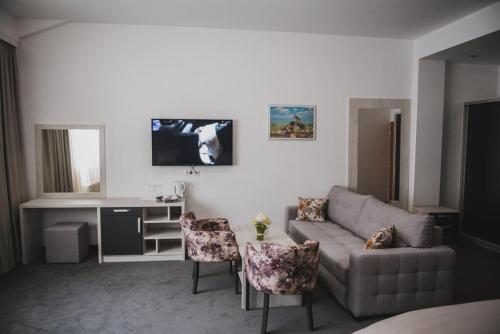 a living room with a couch and a table and chairs at Hotel Bacchus in Livno