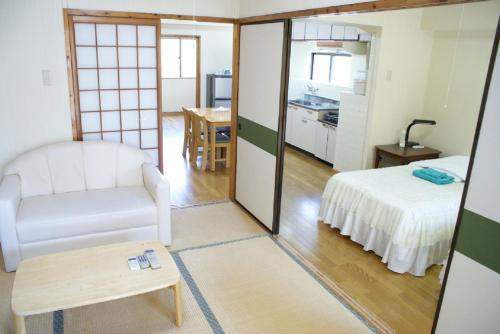 a room with a bed and a chair and a table at Weekly Harbourview Mansion Main Building / Vacation STAY 74570 in Naha