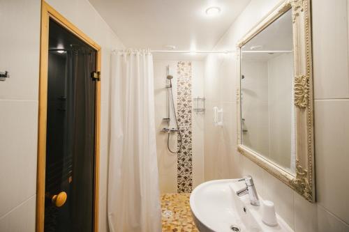 een badkamer met wastafel en douche met spiegel bij Vanaõue Puhkekeskus in Suure-Jaani