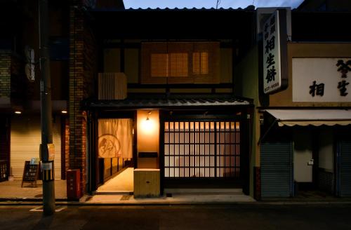 an entrance to a building with a gate at night at Rinn Premium Machiya Kunpu in Kyoto