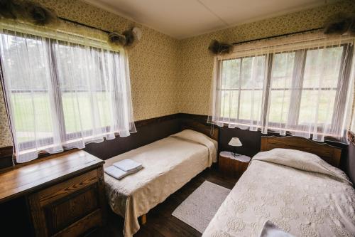 a bedroom with two beds and two windows at Vanaõue in Suure-Jaani