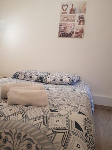 a bed with a comforter and pillows on it at Le Saint Jean in Barbentane