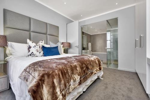 um quarto com uma cama grande e um cobertor de pele falso em Sandton Apartment 15 West Road South em Joanesburgo