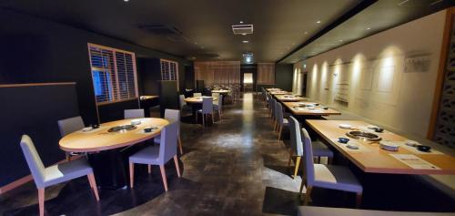 a dining room with long tables and white chairs at Hatagoya Jozankei Shoten-Adult Only in Sapporo