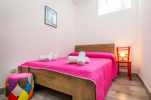 a bedroom with a bed with a pink blanket at Heritage House Captain Bepo's Court in Sumartin