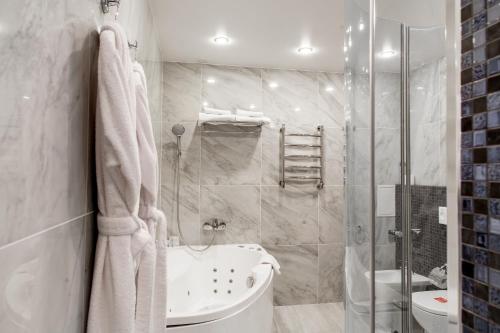 a bathroom with a shower and a tub and a sink at Snowy Owl Hotel in Krasnoyarsk