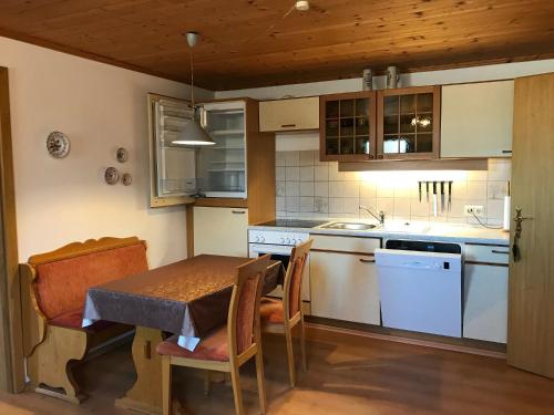 a kitchen with a table and a table and chairs at Ferienwohnung Angelika Neuner in Sulzberg