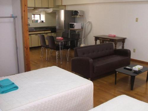 ein Wohnzimmer mit einem Sofa und einer Küche in der Unterkunft Weekly Harbourview Mansion Main Building / Vacation STAY 74562 in Naha