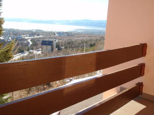 a bench with a view of a city from a window at Penzion Partizan in Smokovce