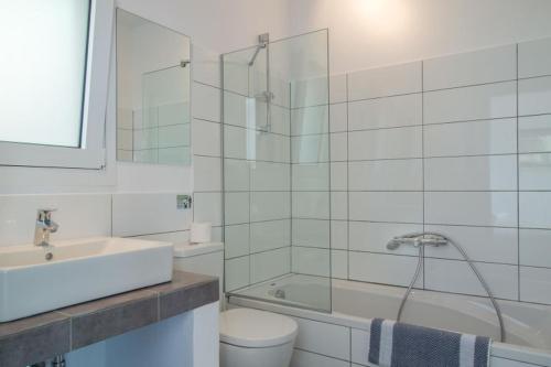 Un baño con inodoro, lavabo y ducha. en Villa Atokos, en Sivota