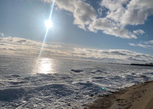 a beach with the sun shining on the water at Valsid puhkemaja in Alajõe