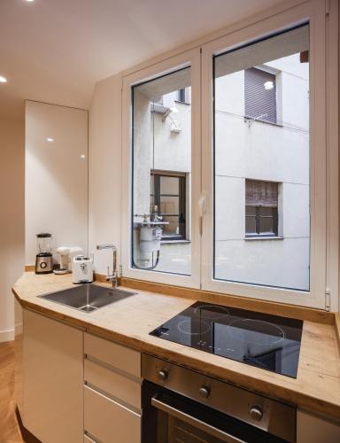 cocina con fregadero y ventana grande en Modern Apartment Gran Via IV Renovated 5BR 5BH, en Madrid
