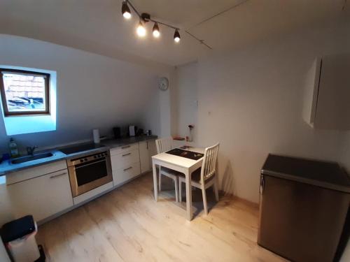 a kitchen with a table and a stove top oven at Heumaden hell und gemütlich eingerichtete 1-Zimmer Wohnung in Lederberg